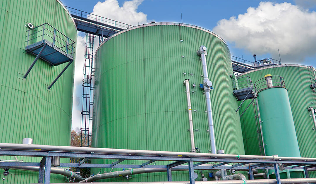 Three big green bioreactors in a biogas plant